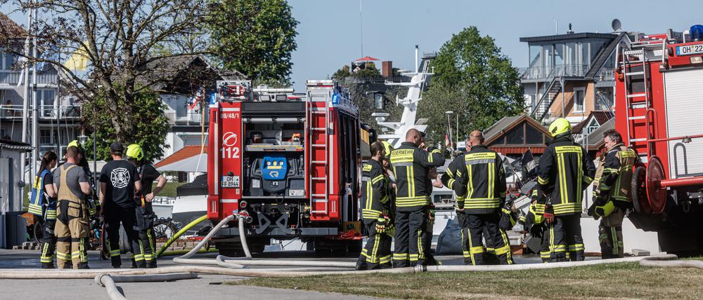 Einsatzkräfte der Feuerwehr stehen im Hafen von Niendorf, wo am Nachmittag einen Gasflasche explodiert sein soll. 