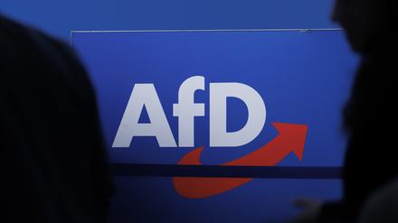Delegierte gehen vor dem Parteilogo bei dem AfD-Bundesparteitag in Magdeburg. 