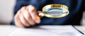 Auditor Using Magnifying Glass For Audit