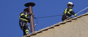 Feuerwehrleute platzieren den Schornstein auf dem Dach der Sixtinischen Kapelle, wo sich die Kardinäle zur Wahl des neuen Papstes versammeln werden.