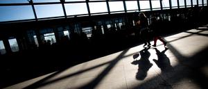 Passanten werfen auf dem Weg zur S-Bahn im Bahnhof Südkreuz in Berlin im Sonnenschein Schatten auf den Boden.