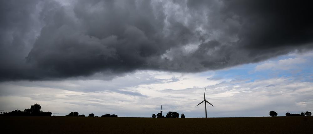 Eine Gewitterfront zieht über ein Windrad hinweg. 