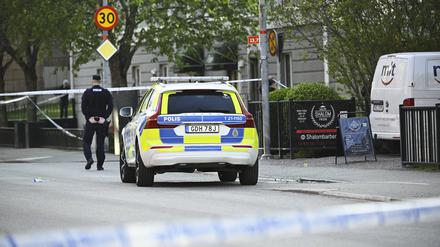Ein Einsatzfahrzeug und ein Polizist stehen Einsatzort nach Schüssen am Vaksala-Platz im Zentrum von Uppsala (Archivbild).