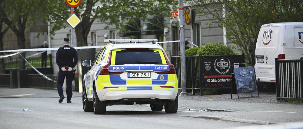 Ein Einsatzfahrzeug und ein Polizist stehen Einsatzort nach Schüssen am Vaksala-Platz im Zentrum von Uppsala (Archivbild).