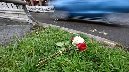 Am Tag nach dem Unfall liegen Rosen am Straßenrand. 