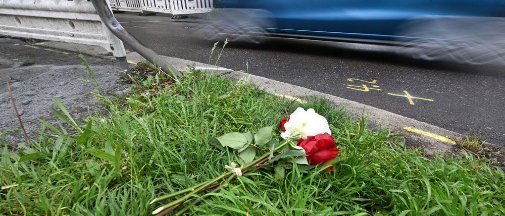 Am Tag nach dem Unfall liegen Rosen am Straßenrand. 