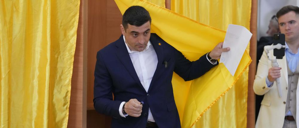 Präsidentschaftskandidat George Simion verlässt eine Wahlkabine.