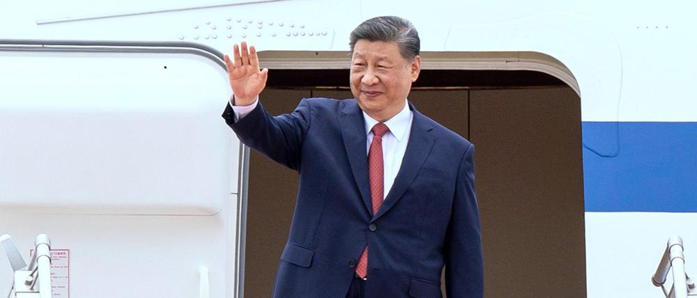 Chinas Präsident Xi Jinping winkt beim Einstieg in ein Flugzeug.