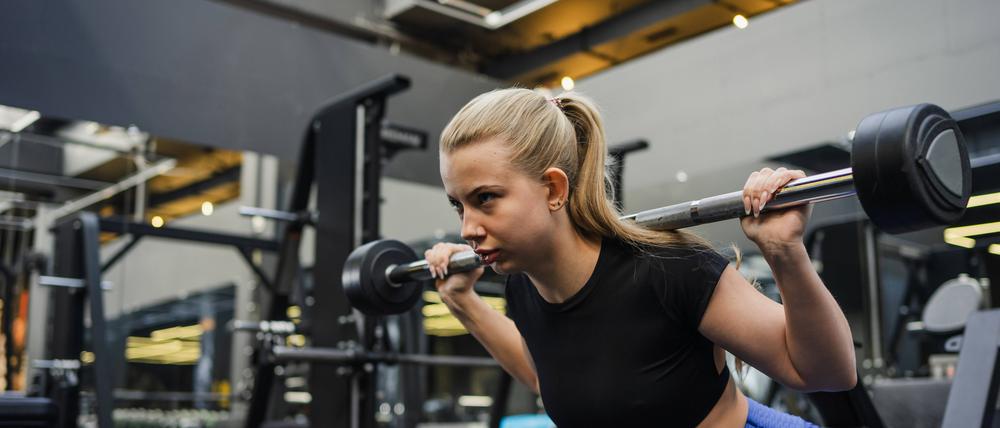 Eine junge Frau trainiert in einem Fitnessstudio.