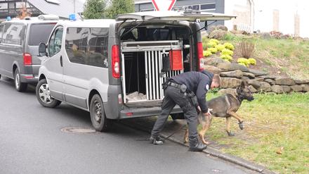 Ein Polizist und ein Suchhund bereiten sich auf einen Einsatz rund anderthalb Wochen nach der Tötung einer dreiköpfigen Familie im Westerwald vor (Archivbild).