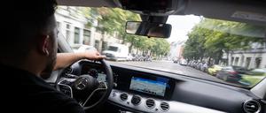 Ein Fahrer fährt in einem Taxi, das auch über Uber und Bolt gebucht werden kann.