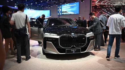 Menschen stehen um einen BMW 7 auf einem Messestand.