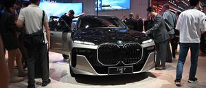 Menschen stehen um einen BMW 7 auf einem Messestand.