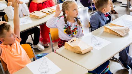 Die 6-jährige Yeva aus der Ukraine hebt bei ihrer Einschulung in der Tempelherren-Grundschule im Berliner Stadtteil Tempelhof die Hand. Sie ist mit ihrer Mutter von Schytomyr nach Berlin geflohen.