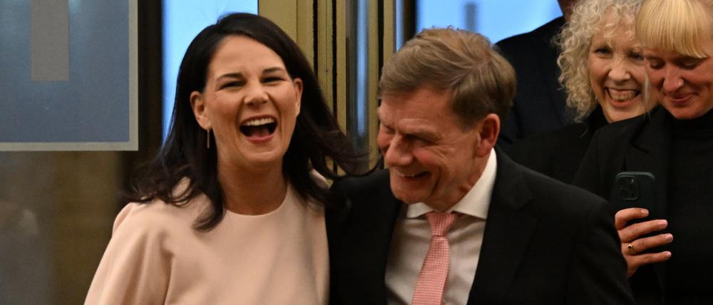 Der amtierende Außenminister Johann Wadephul und die ehemalige Außenministerin lachen Arm in Arm bei der Amtsübergabe.