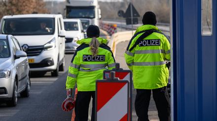 Beamte der Bundespolizei stehen bei der Eireisekontrolle am deutsch-polnischen Autobahngrenzübergang A15 bei Forst und beobachten die Fahrzeuge.