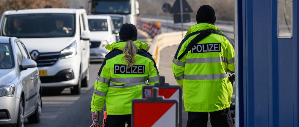 Beamte der Bundespolizei stehen bei der Eireisekontrolle am deutsch-polnischen Autobahngrenzübergang A15 bei Forst und beobachten die Fahrzeuge.