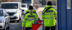 Beamte der Bundespolizei stehen bei der Eireisekontrolle am deutsch-polnischen Autobahngrenzübergang A15 bei Forst und beobachten die Fahrzeuge.