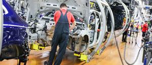 Ein Mitarbeiter in der Autoindustrie arbeitet in einem Werk. 