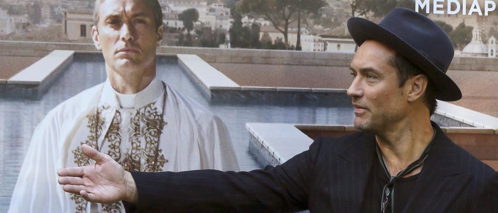 Jude Law vor einem Plakat mit sich als Papst Pius XIII. in der Serie „The Young Pope“. (Archivbild)