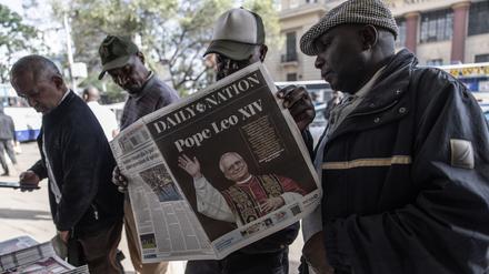 Menschen in der kenianischen Hauptstadt Nairobi schauen in Zeitungen, die über die Papstwahl berichten.