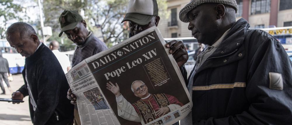 Menschen in der kenianischen Hauptstadt Nairobi schauen in Zeitungen, die über die Papstwahl berichten.
