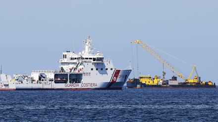 Der Lastkahn Hebo Lift 2 ist am Ort des Schiffbruchs der Superjacht „Bayesian“ vor der Insel Sizilien im Einsatz. Ein Boot der Küstenwache verhindert, dass sich Neugierige annähern können.