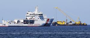 Der Lastkahn Hebo Lift 2 ist am Ort des Schiffbruchs der Superjacht „Bayesian“ vor der Insel Sizilien im Einsatz. Ein Boot der Küstenwache verhindert, dass sich Neugierige annähern können.