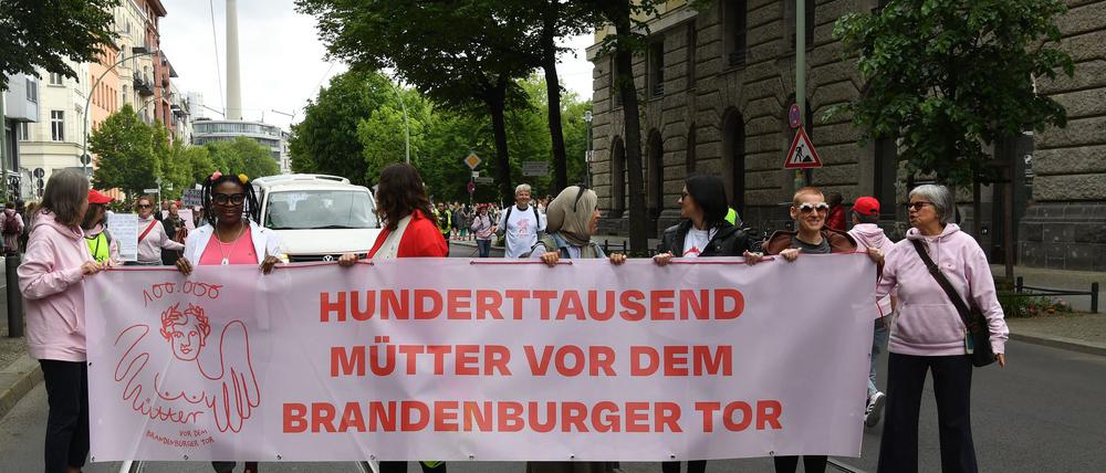 Demonstrantinnen und Demonstranten fordern mehr Unterstützung für Mütter.