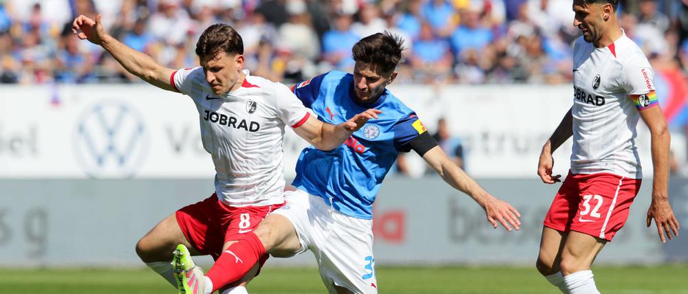 Freiburgs Maximilian Eggestein (l) und Kiels Armin Gigovic kämpfen um den Ball.