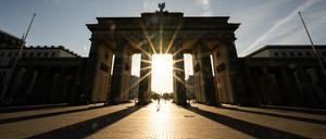 ARCHIV - 11.08.2024, Berlin: Die Sonne geht hinter dem Brandenburger Tor auf. (zu dpa: «Viel Sonne und milde Temperaturen zur neuen Woche») Foto: Christophe Gateau/dpa +++ dpa-Bildfunk +++