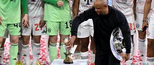 Bayern-Trainer Vincent Kompany stellt bei der Meisterparty eine Kakadu-Figur auf den Sockel.