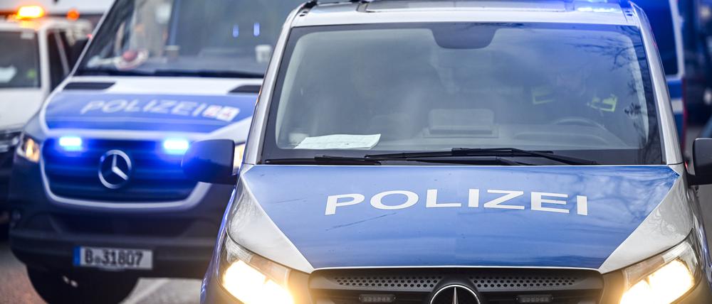  Polizeiautos mit eingeschalteten Scheinwerfern und Blaulicht. 