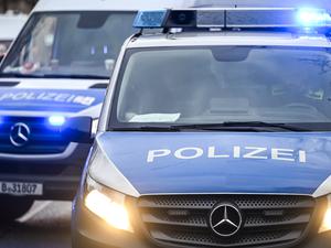  Polizeiautos mit eingeschalteten Scheinwerfern und Blaulicht. 