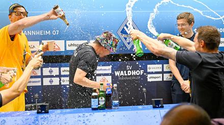 Dresdens Spielern feiern mit einer Bierdusche ihres Trainers Thomas Stamm (M) den Aufstieg in die 2. Fußball-Bundesliga.