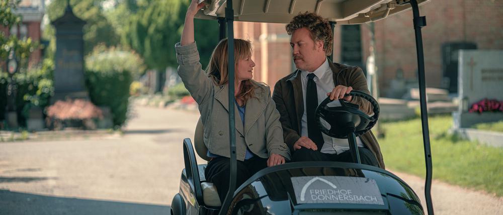 Ursula Fink (Julia Jentsch) und Heli Wondratschek (Nicholas Ofczarek) in einer Szene aus der ersten Staffel der Serie „Drunter und Drüber – Chaos auf dem Friedhof“ (Prime Video).