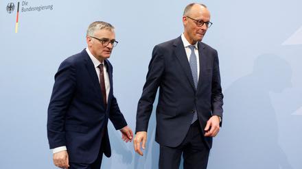 Der Sprecher der neuen Bundesregierung, Stefan Kornelius (l.), und Bundeskanzler Friedrich Merz verabschieden sich nach einer Pressekonferenz am 12. Mai.
