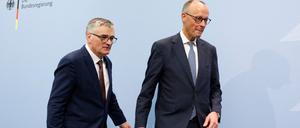 Der Sprecher der neuen Bundesregierung, Stefan Kornelius (l.), und Bundeskanzler Friedrich Merz verabschieden sich nach einer Pressekonferenz am 12. Mai.