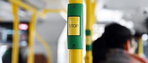 Ein „Stop“-Knopf an einer Haltestange in einer Straßenbahn ist in Nahaufnahme zu sehen.