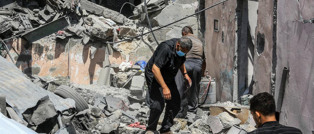 Mai 2025. Palästinenser inspizieren die Schäden, die ein israelischer Luftangriff auf mehrere Häuser in einem Lager westlich von Khan Yunis verursacht hat.