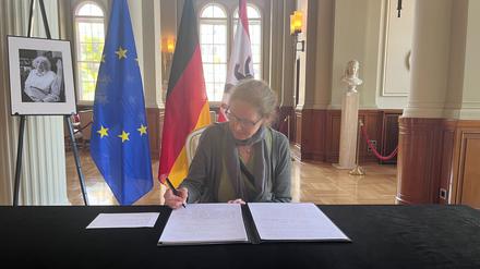Kesshrin Albert unterschreibt im Kondolenzbuch für Margot Friedländer.