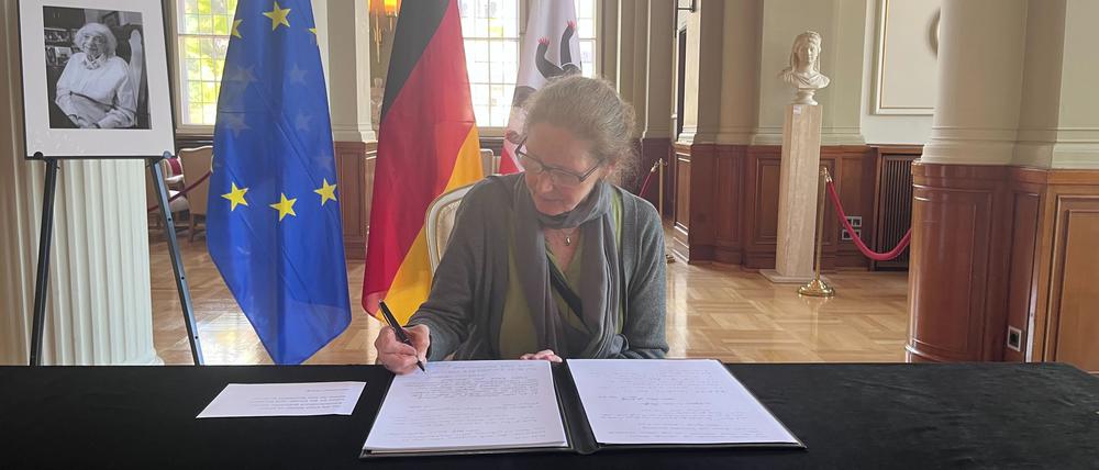 Kesshrin Albert unterschreibt im Kondolenzbuch für Margot Friedländer.