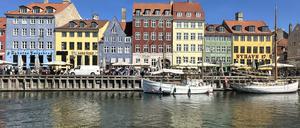 ARCHIV - 29.04.2025, Dänemark, Kopenhagen: Passanten gehen am Nyhavn (neuer Hafen) entlang. Der Nyhavn mit seinen bunten Häuschen zählt zu den wichtigsten Sehenswürdigkeiten der dänischen Hauptstadt. (zu dpa: «Kopenhagen belohnt Gäste wieder für nachhaltigeres Reisen») Foto: Steffen Trumpf/dpa +++ dpa-Bildfunk +++