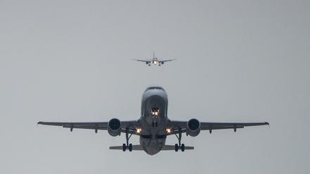 Ein Airbus 320 startet während dahinter ein Airbus 319  im Landeanflug ist. 