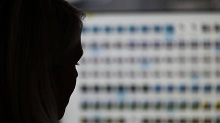 Auf dem Bild ist die Silhouette des Kopfes einer Frau vor einem unscharfen Computerbildschirm zu sehen (Symbolbild).