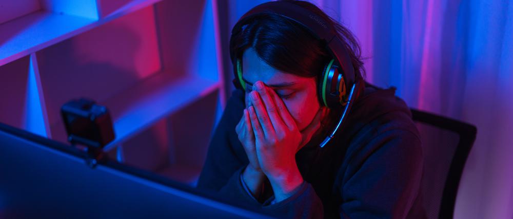 Game stream concept, Male streamer feeling stressed after live streaming of losing game tournament.