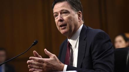 Der ehemalige FBI-Direktor steht an einem Pult vor einem Mikrofon und gestikuliert mit den Händen.