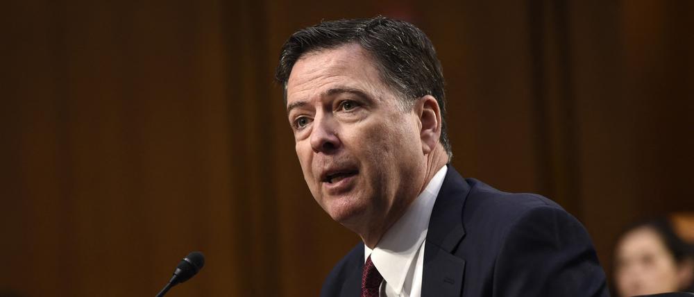 Der ehemalige FBI-Direktor steht an einem Pult vor einem Mikrofon und gestikuliert mit den Händen.