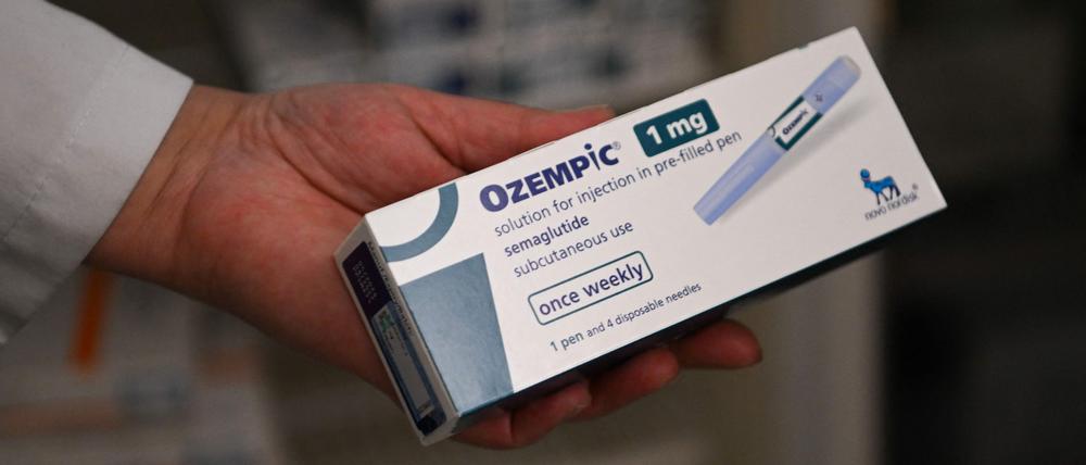 Auf dem Bild sieht man eine Hand, die eine Packung der Abnehmpille Ozempic hält.