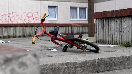 Ein Kinderfahrrad liegt in einem Aufgang zu einem Plattenbau.